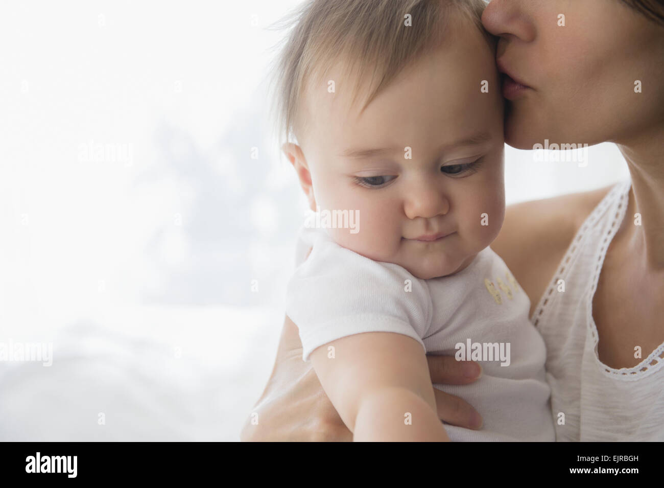 Close up of mixed race Mère embrassant bébé sur le front Banque D'Images
