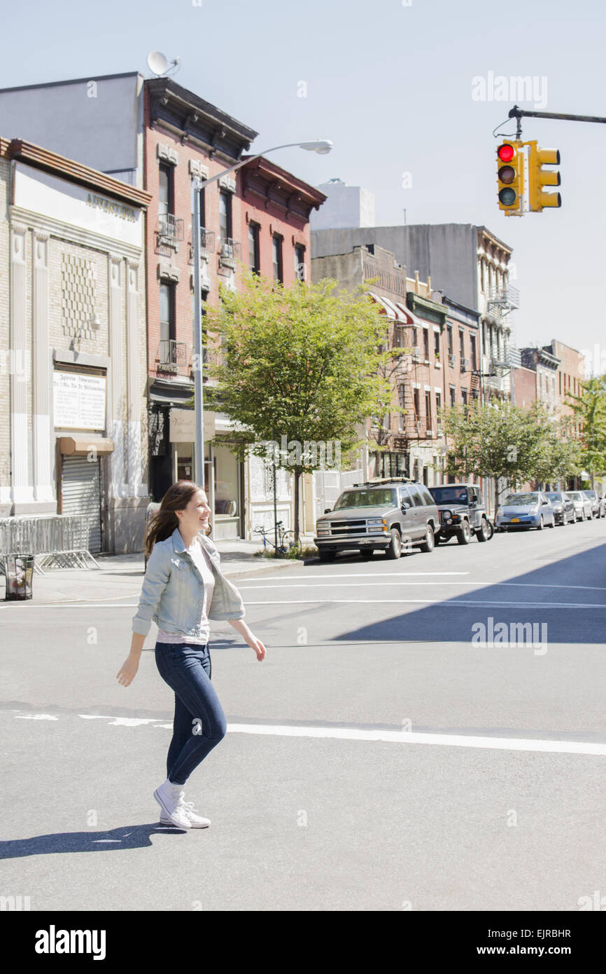 Caucasian woman crossing street urbain Banque D'Images