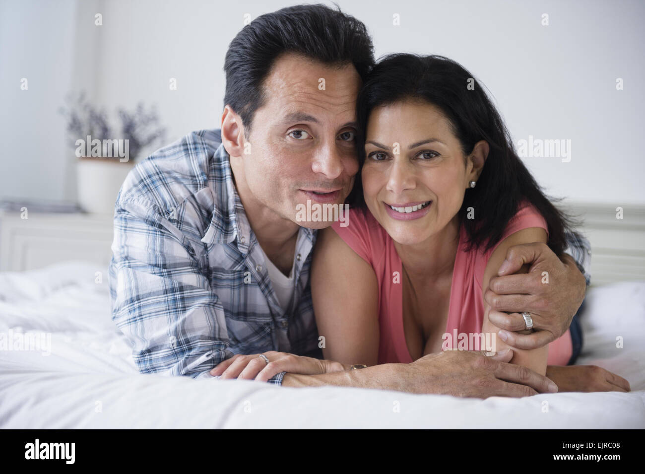 Close up of couple hugging on bed Banque D'Images