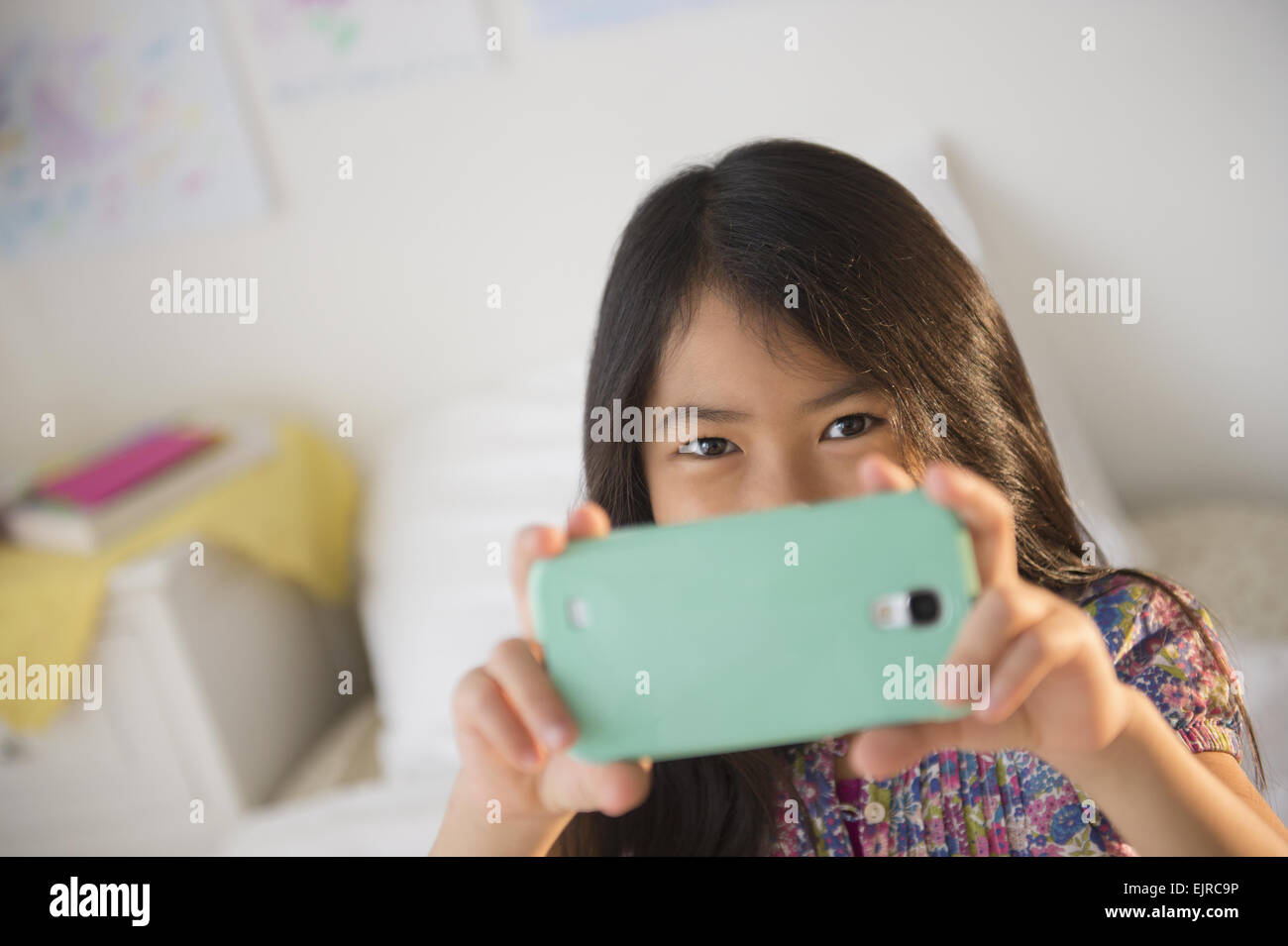 Smiling fille vietnamienne en tenant la photographie de téléphone cellulaire Banque D'Images