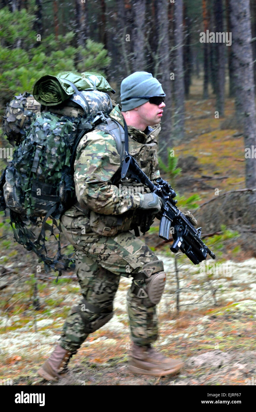 US Army commando de reconnaissance entre dans une forêt après une infiltration d'eau au cours de l'exercice Opération Bouclier d'été 30 mars 2015 près de la Base Militaire Adazi, la Lettonie. Banque D'Images