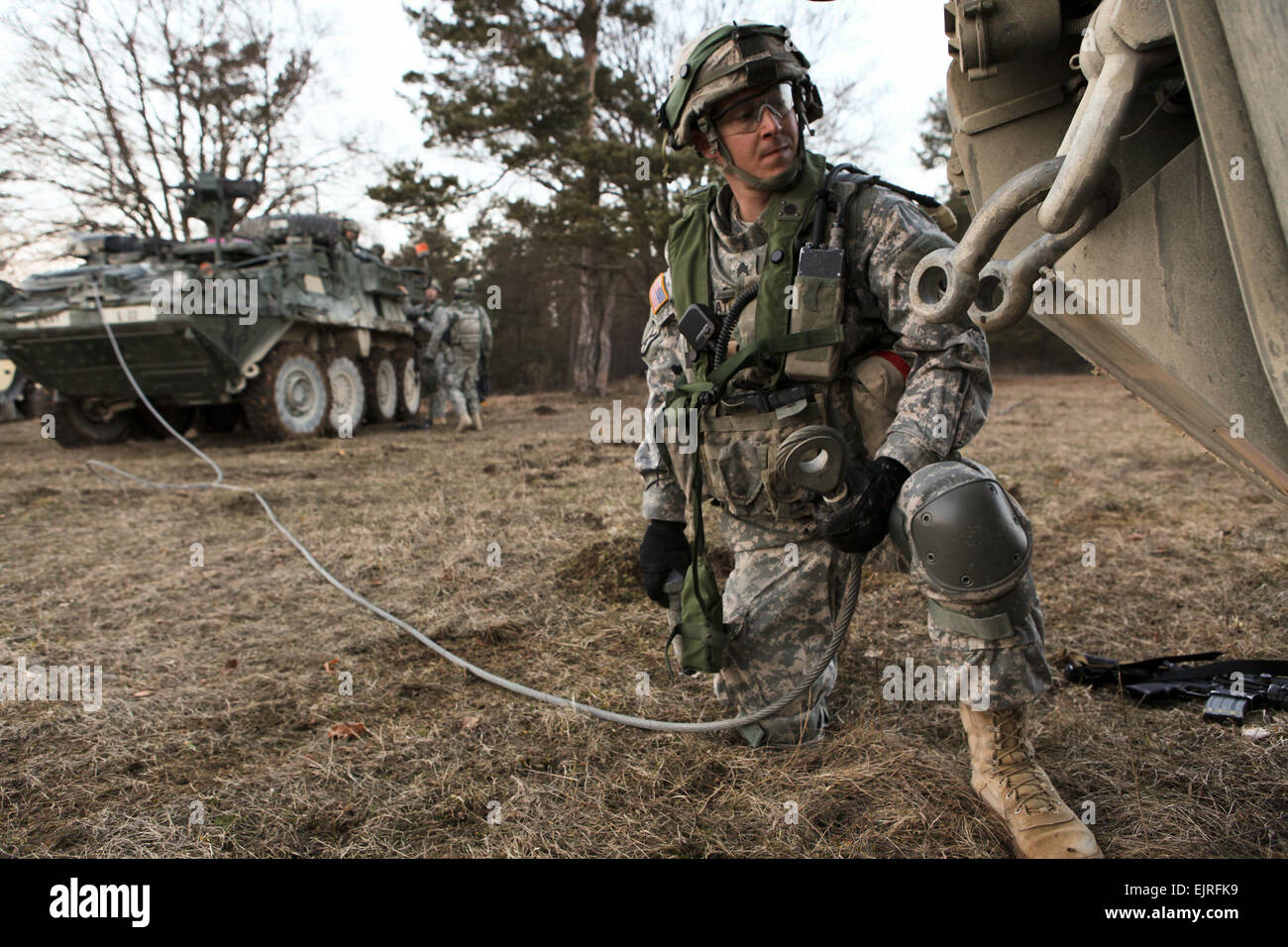 Le sergent de l'armée américaine. Daniwel Dana de la foudre Troop, 3e Escadron, 2e régiment de cavalerie à un remorquage Crochets câble à un véhicule blindé Stryker au cours d'un exercice de répétition de mission à l'inculcation de préparation interarmées multinationale Centre à Hohenfels, Allemagne, le 8 mars 2013. Le MRE est conçu pour assurer le déploiement d'unités sont capables de mener des opérations d'assistance des forces de sécurité afin de permettre aux Forces nationales de sécurité à assumer la responsabilité principale pour les opérations à l'appui de la gouvernance et de la sécurité et de vaincre l'insurrection au sein de la République islamique d'Afghanistan. La CPS. Tristan Bolden/pas revu Banque D'Images