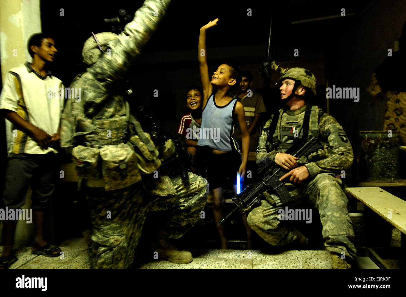 Circuit de l'armée américaine. Travis Grimes, gauche, haute de cinq ans un garçon irakien comme circuit. Homer Thompson cherche sur pendant une opération de bouclage et de recherche de Shulla, l'Iraq, le 22 juin 2008. Les soldats sont affectés au 1er peloton, Compagnie Bravo, 1er bataillon du 502e Régiment d'infanterie. Le s.. Manuel J. Martinez, Banque D'Images