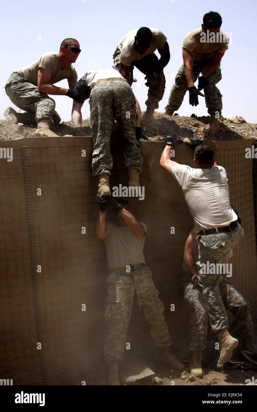 Des soldats américains de la 3ème Compagnie Section B, 1er Bataillon, 27e Régiment d'infanterie, 2e Stryker Brigade Combat Team, Multi-National Division-Baghdad, aider leurs coéquipiers escalader un mur au cours de l'un mille de Steeple Chase. Les soldats ont concouru dans le barzoï Squad la concurrence au poste de sécurité commune Sheik Amir, au nord-ouest de Bagdad, pour célébrer le Jour de l'indépendance le 4 juillet 2008. Banque D'Images