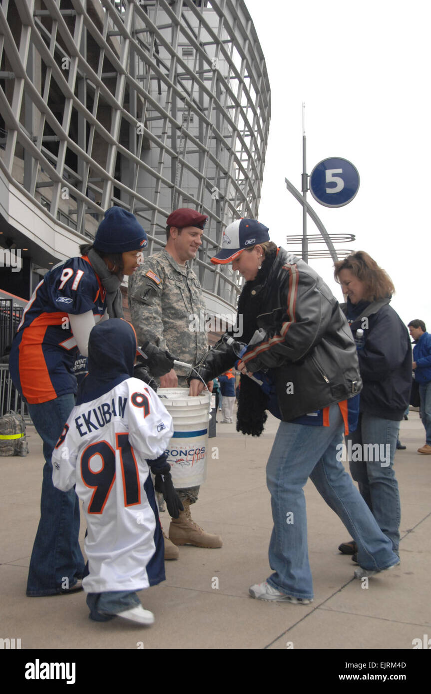 DENVER - Le Sgt. Joshua Gillespie, de la Garde nationale du Colorado le long Ekumban avec Karen, femme de joueur de ligne défensive Ebenezer, et leur fils Ezra, stand à l'extérieur d'un embarquement au Denverís INVESCO Field at Mile High parmi le trafic de pied de Broncos fans pour aider à recueillir des fonds pour le Colorado a faim et de sans-abri le 12 octobre, 2008. Soldats affectés à la Garde nationale du Colorado ont donné leur temps pour aider à la collecte d'aliments les épouses, qui a recueilli plus de 37 000 $. Le s.. Liesl Marelli Banque D'Images