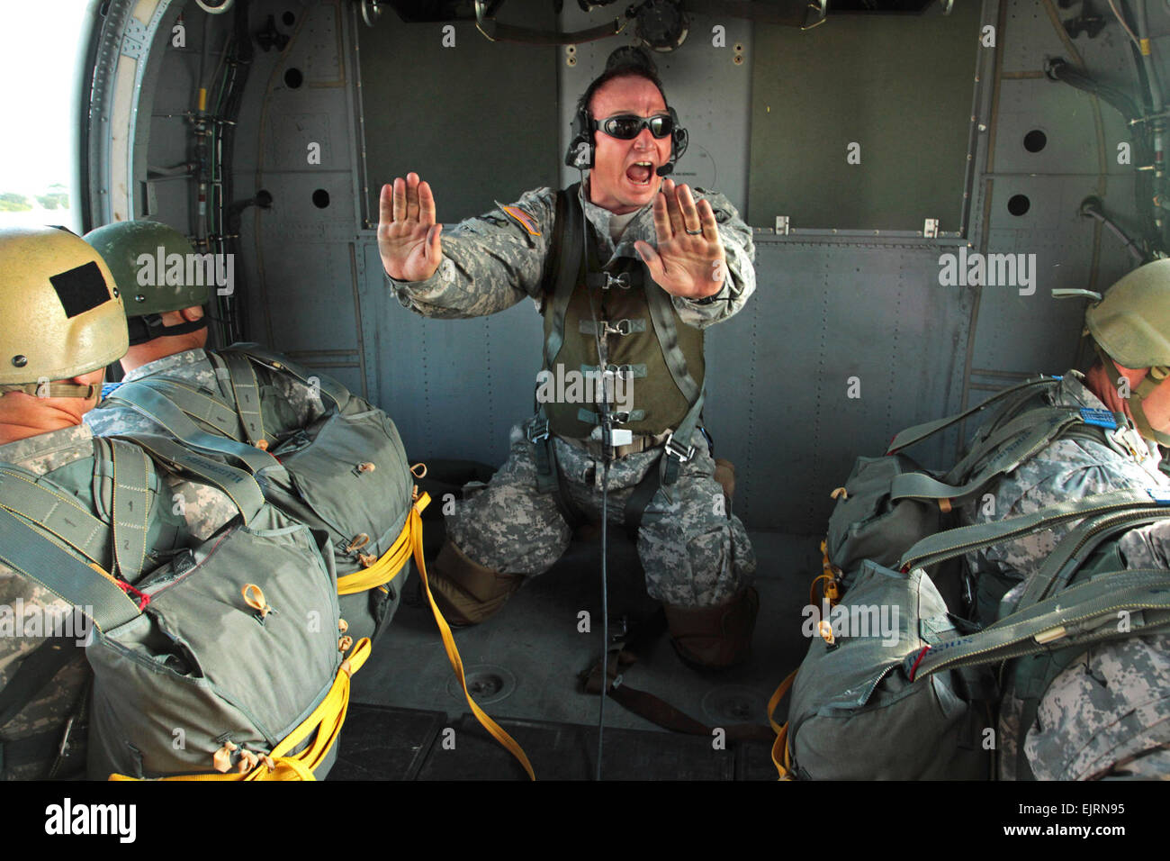 Le Sgt. 1re classe William Baker, un jumpmaster affectés à des opérations spéciales du commandement, crie des instructions pour parachutistes avant qu'ils sautent d'un hélicoptère MH-60 hélicoptère lors d'une opération aéroportée le 16 avril à Homestead Air Reserve Base, en Floride, le sgt de l'armée américaine. 1re classe Alex Licea, SOCSOUTH Affaires Publiques Banque D'Images