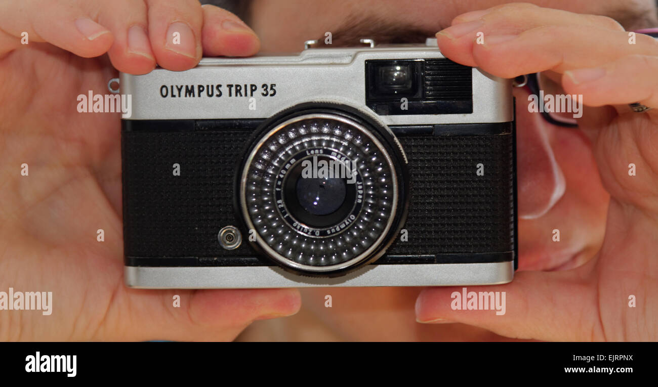 Une femme tenant le classique Olympus TRIP 35 Appareil photo compact Banque D'Images
