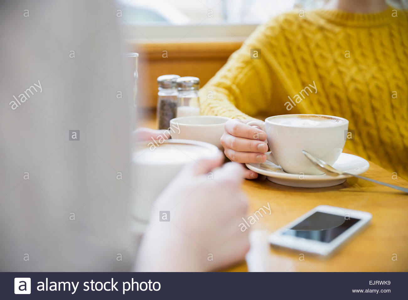 Les femmes de boire un cappuccino dans le café Banque D'Images