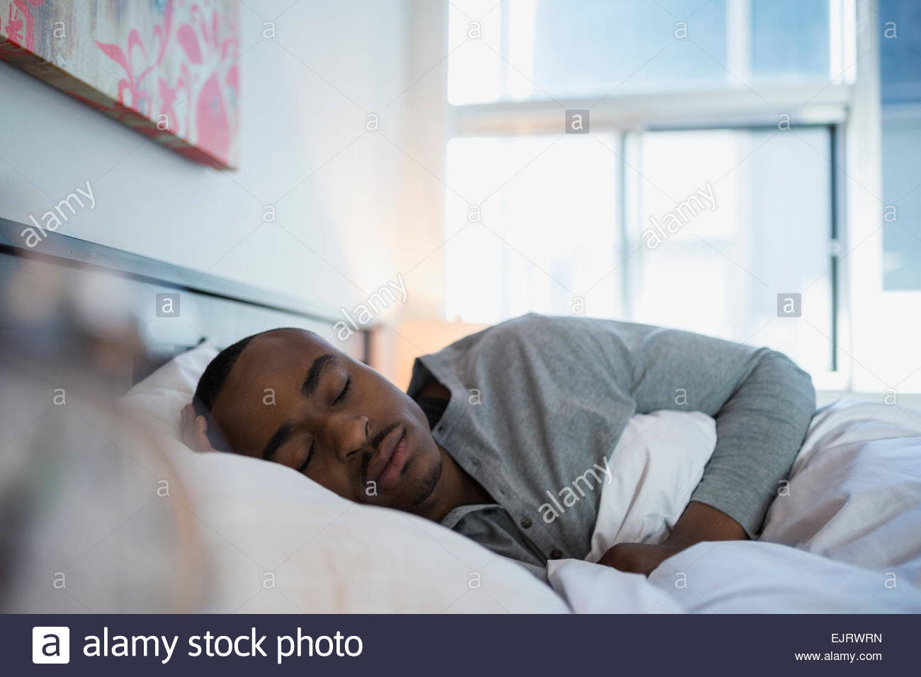 L'homme serein en couchage lit le matin Banque D'Images