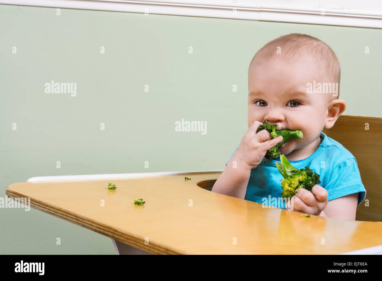 Funny baby essayer le brocoli pour la première fois Banque D'Images