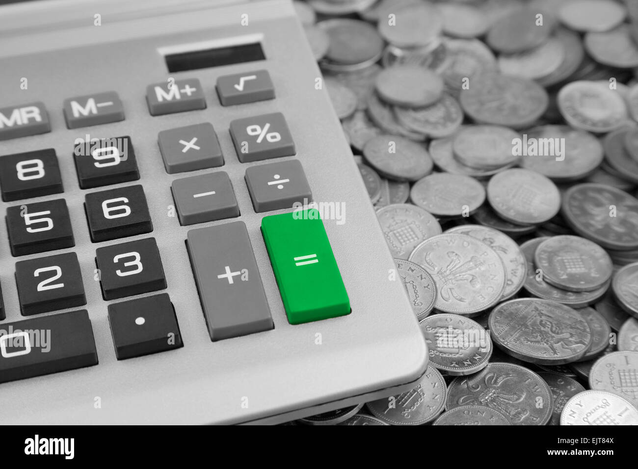 Une calculatrice de bureau avec un livre vert bouton Egal et Banque d'Angleterre un et deux pence pence Coins Banque D'Images