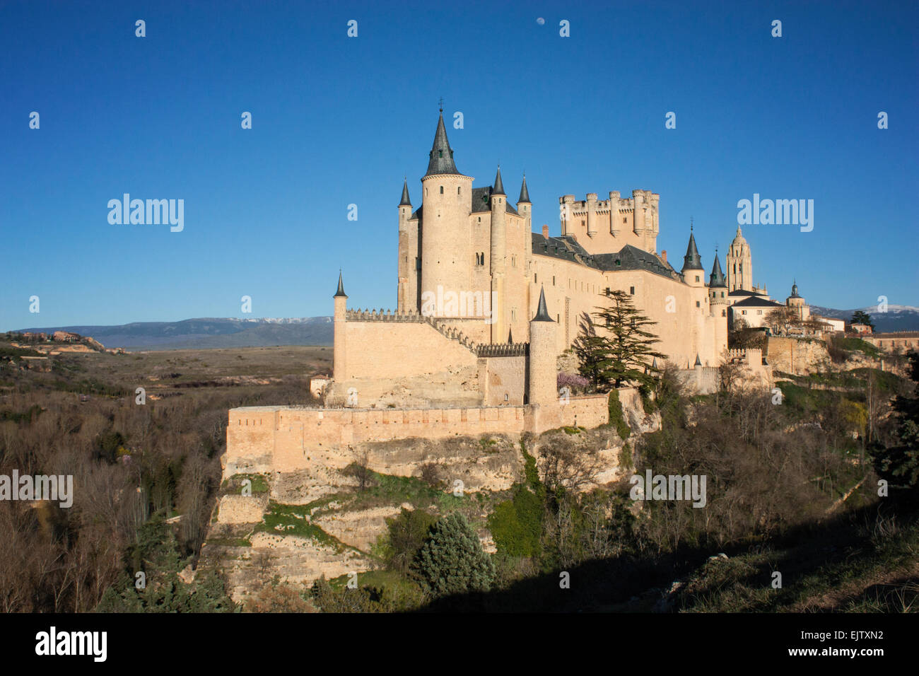 Beau château médiéval en pierre au-dessus de roches avec des montagnes en arrière-plan. Un ciel bleu avec la lune et entouré par de Banque D'Images