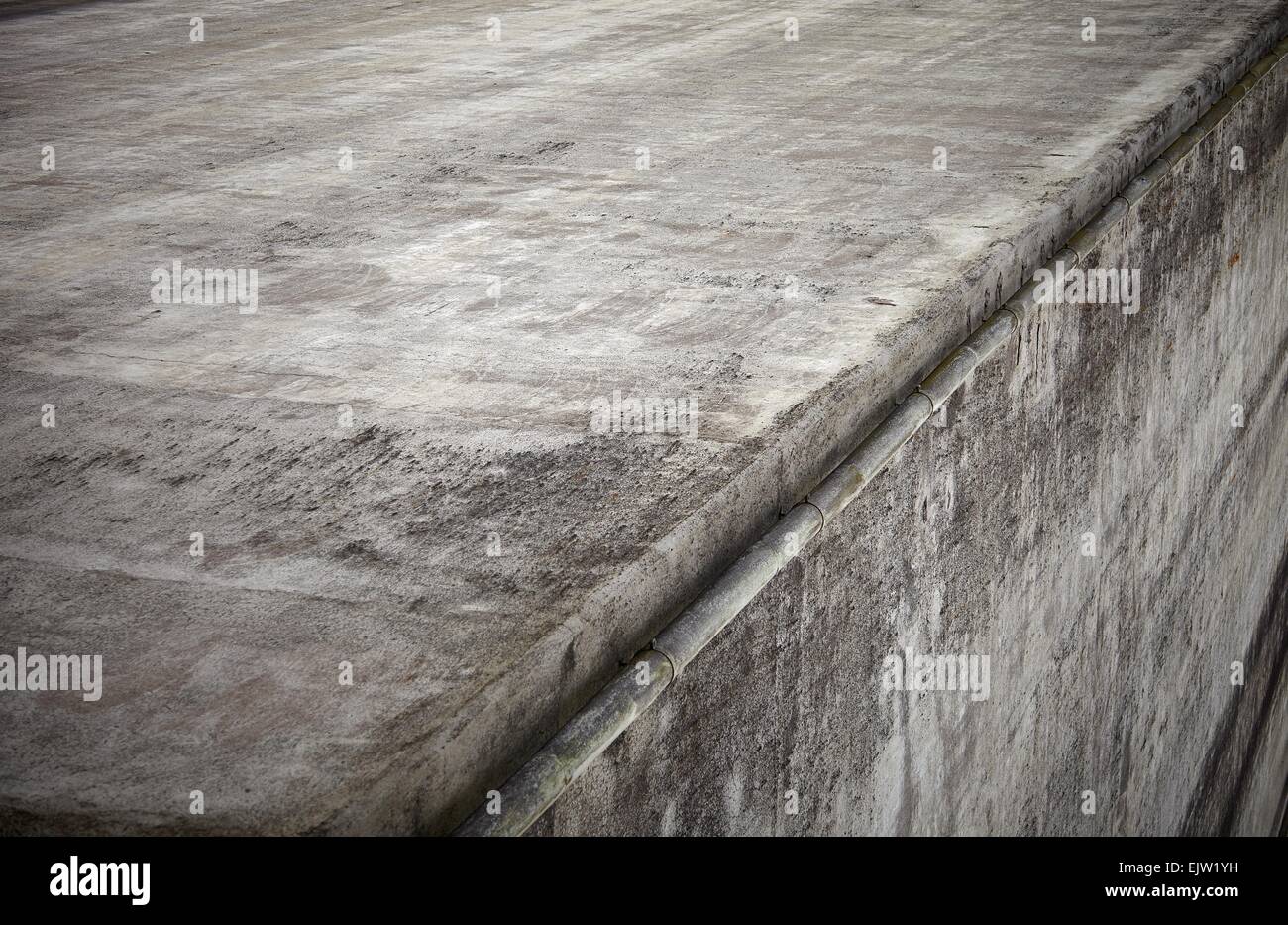 Mur de béton gris coin avec un look grunge. Résumé froid avec un gros plan bâtiment chute sur le bord du mur. Un très approximative Banque D'Images