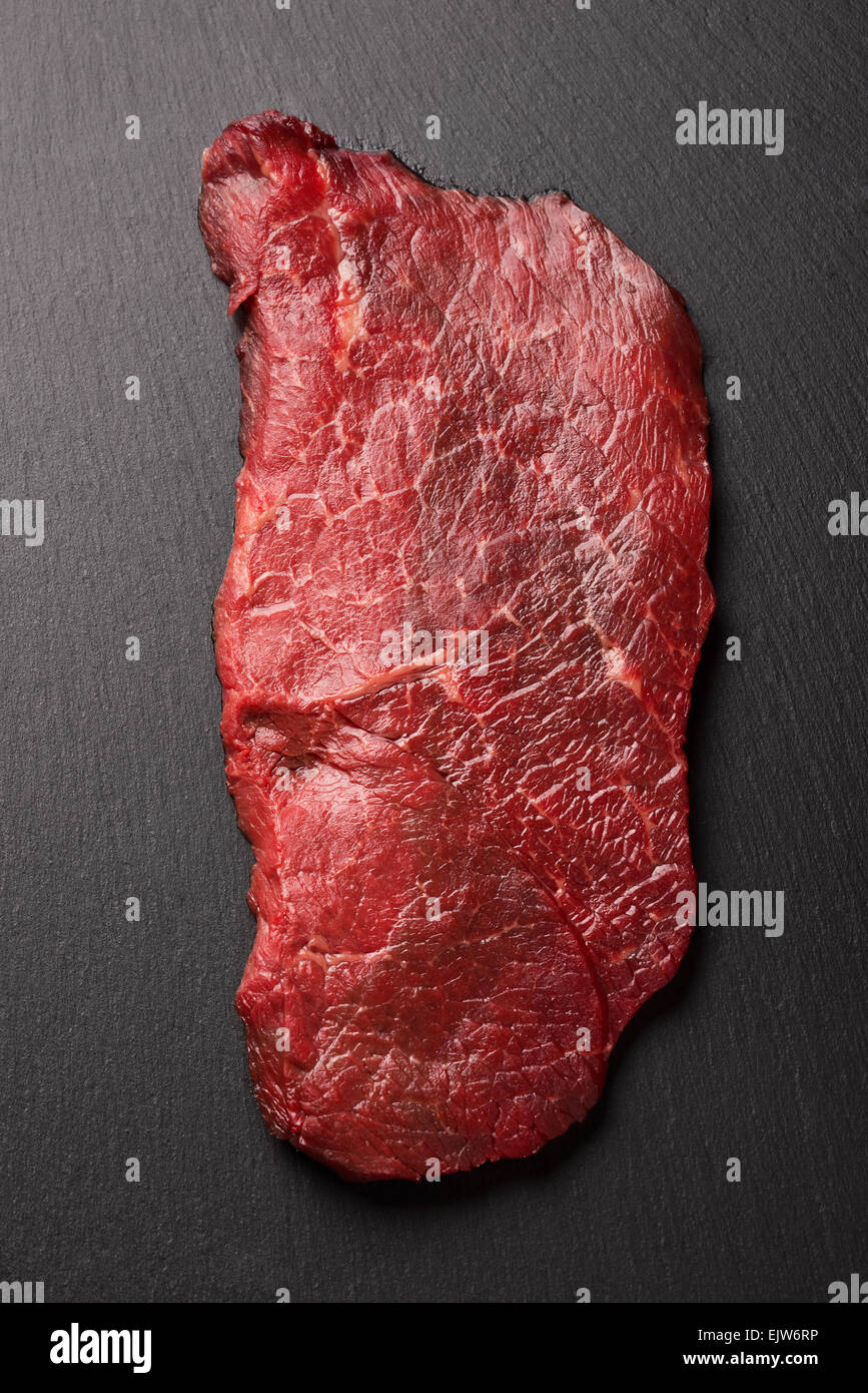 Steak de boeuf cru sur pierre noire Banque D'Images