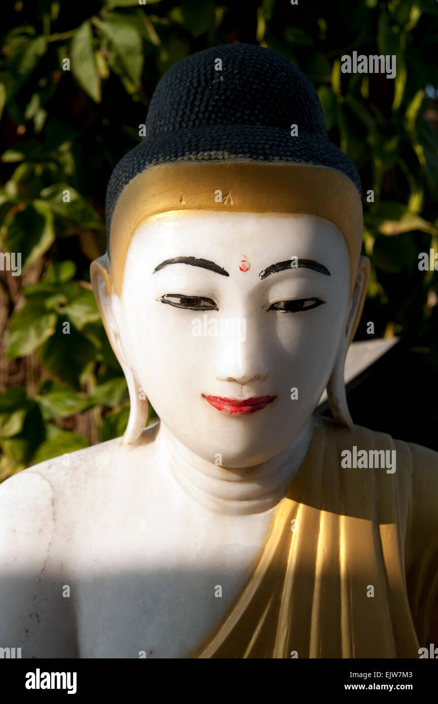 Face close up d'une statue de Bouddha en marbre blanc translucide avec de l'or peint dispose et peignoirs dans Myanmar Birmanie Banque D'Images