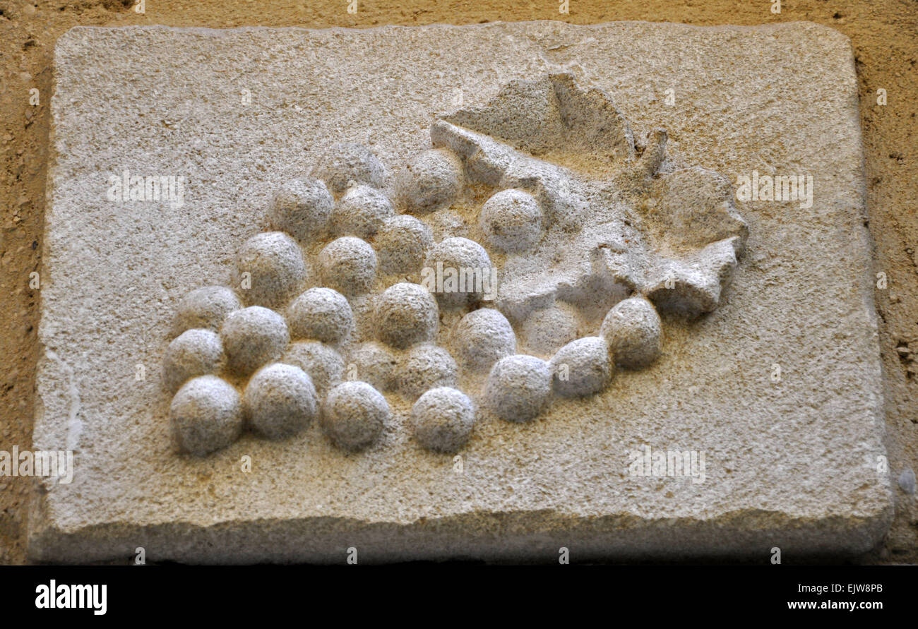 Une grappe de raisins en pierre sculptée sur un immeuble dans le vieux towm de Vaison-la-Romaine, en Provence, France Banque D'Images