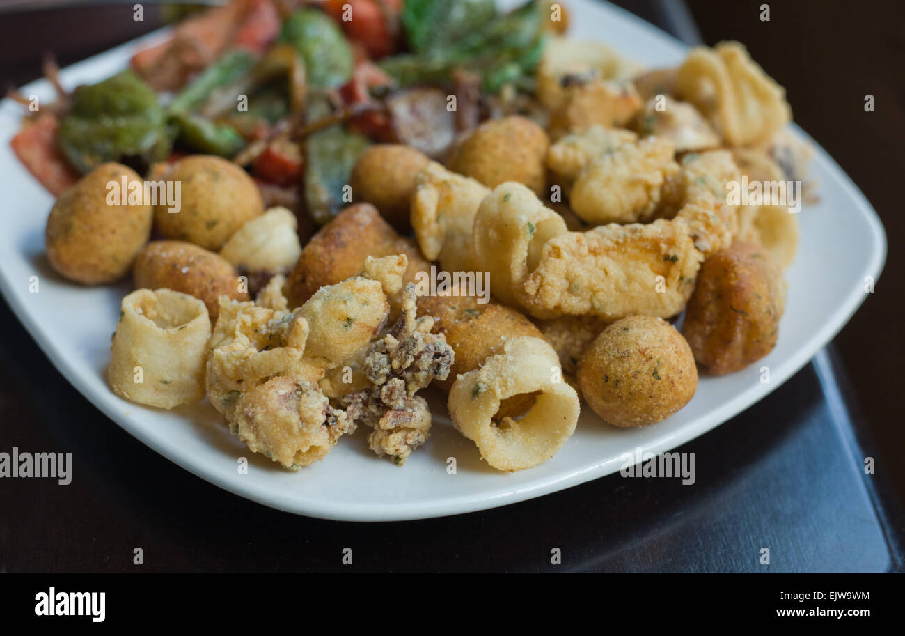 Un snack-plateau avec plusieurs produits de fruits de mer frites et poivrons grillés Banque D'Images