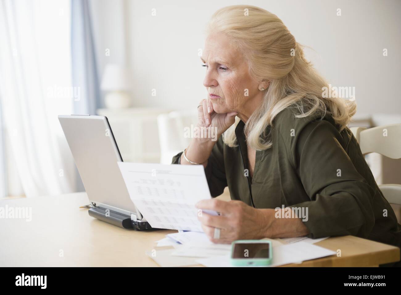 Senior woman payer les factures en ligne Banque D'Images