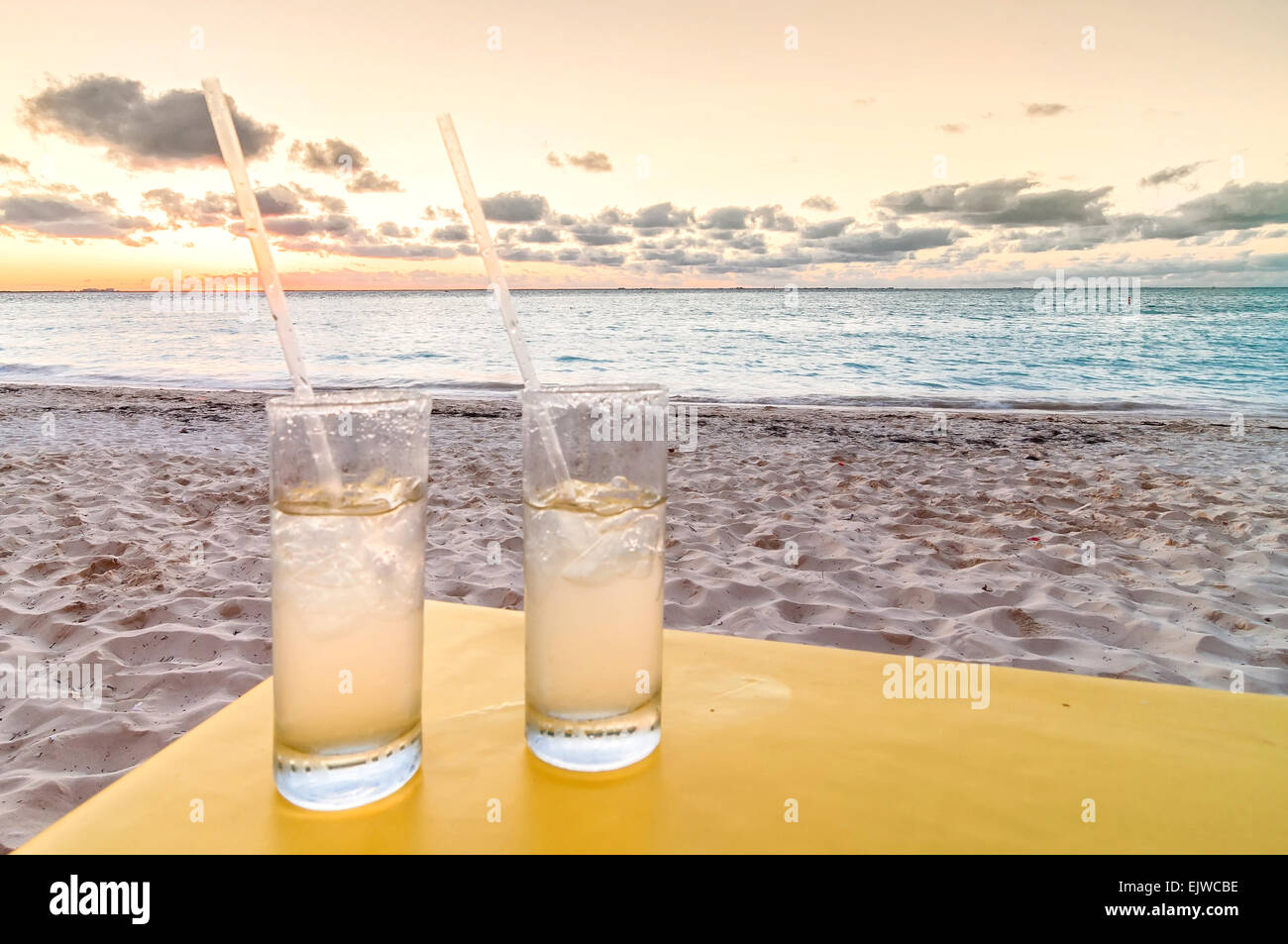 Vacances concept avec des cocktails sur la plage tropicale le tableau au coucher du soleil Banque D'Images