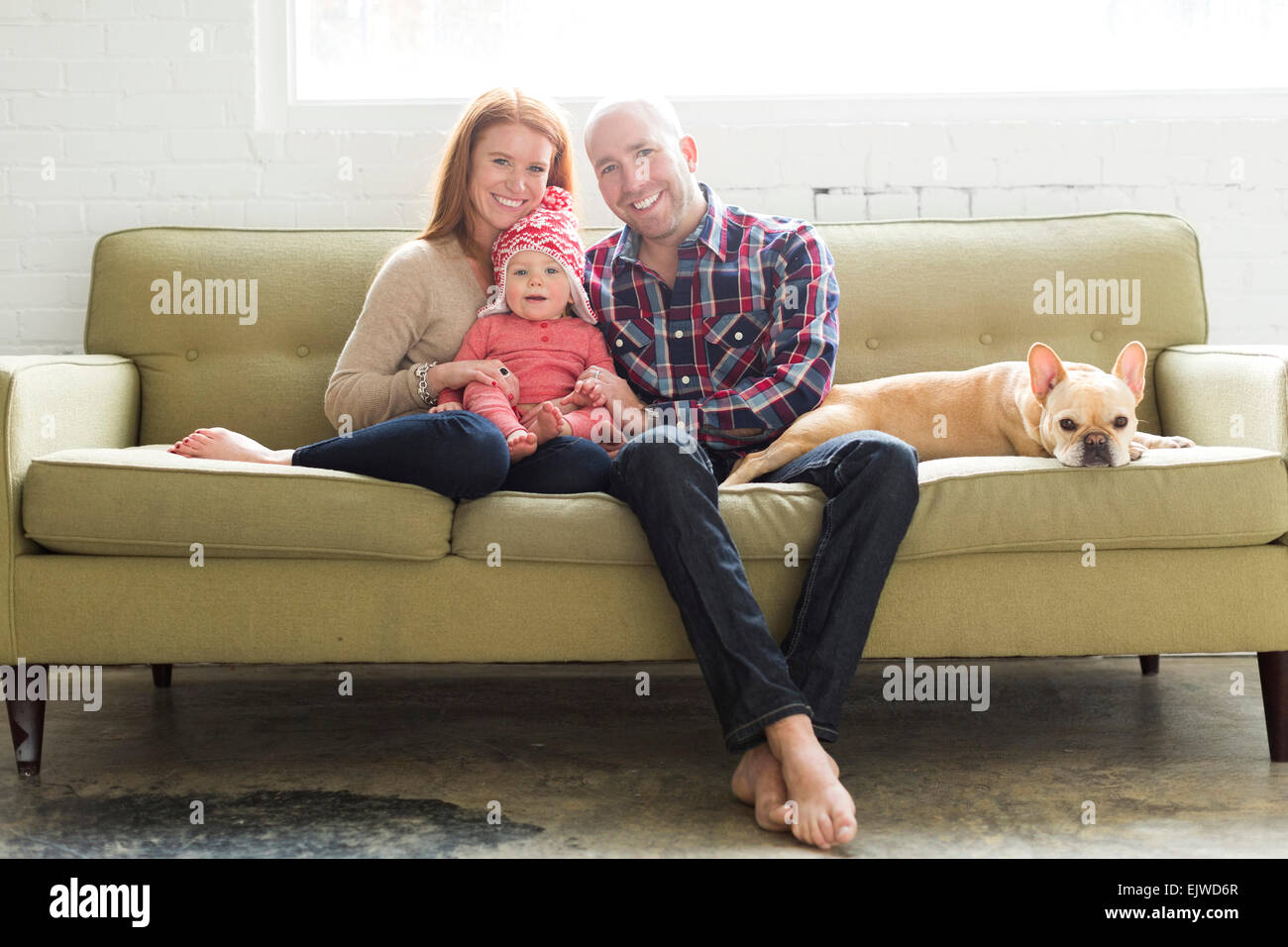 Famille avec baby son (2-3) et sur le canapé du pug Banque D'Images