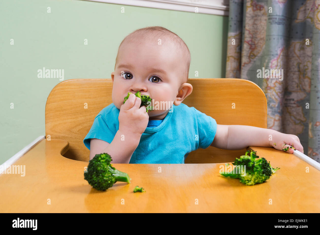 Mignon bébé manger le brocoli Banque D'Images
