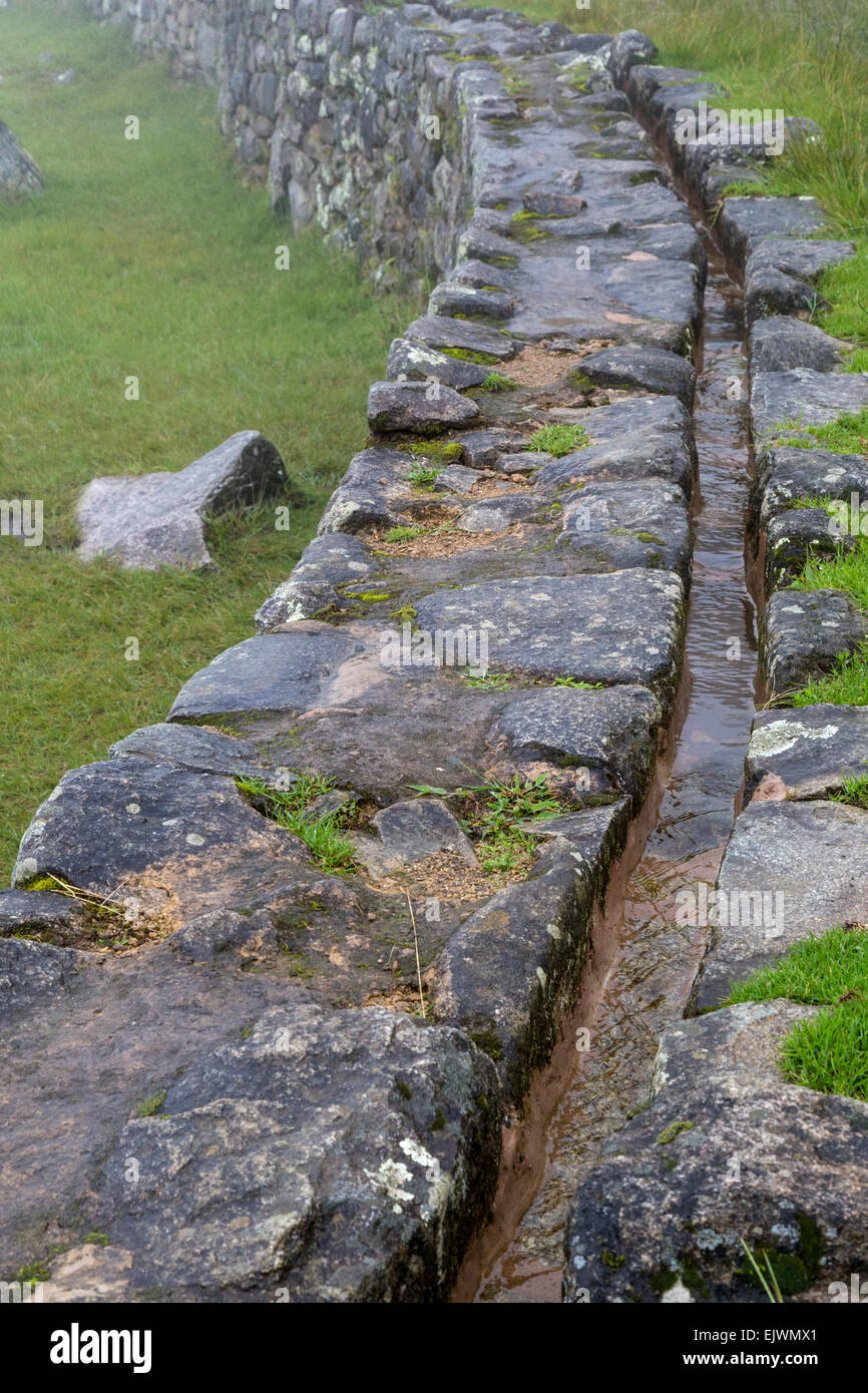 Au Pérou, le Machu Picchu. Canal apportant l'eau d'une source de montagne dans le centre ville. Banque D'Images