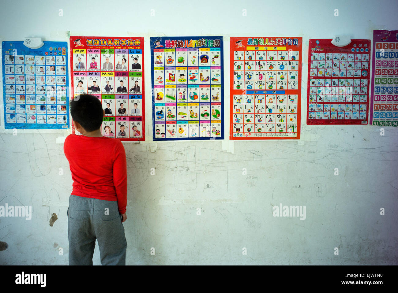 Hefei, Chine, Anhui Province. 1er avril 2015. Un garçon autiste regarde lire autocollants dans un centre de réadaptation à Hefei, Chine de l'est l'Anhui Province, le 1er avril 2015. Quelque 10 enfants autistes de familles pauvres, à un âge moyen de 6 ans, ont reçu un traitement au centre de réadaptation. Le 2 avril marque la huitième Journée mondiale de sensibilisation à l'autisme. © Guo Chen/Xinhua/Alamy Live News Banque D'Images