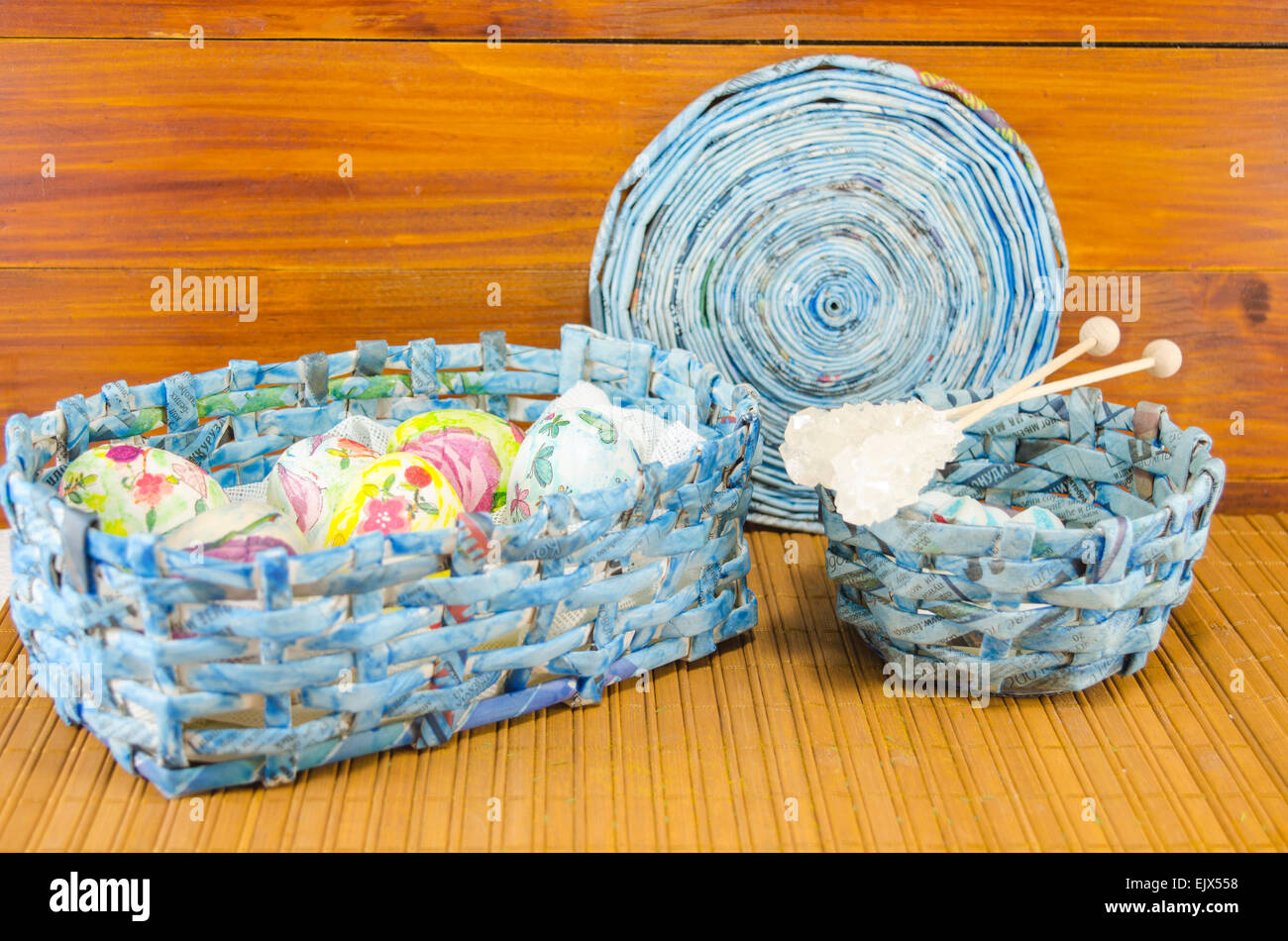 Blue panier plein d'Œufs de Pâques colorés main dans decoupage contre une table en bois Banque D'Images