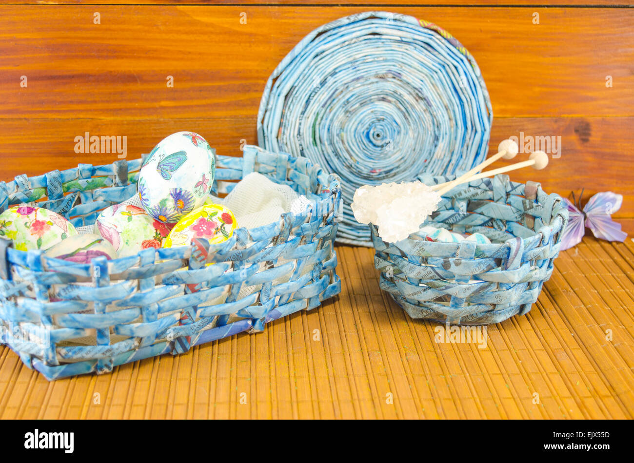 Blue panier plein d'Œufs de Pâques colorés main dans decoupage tourné contre un fond de bois Banque D'Images