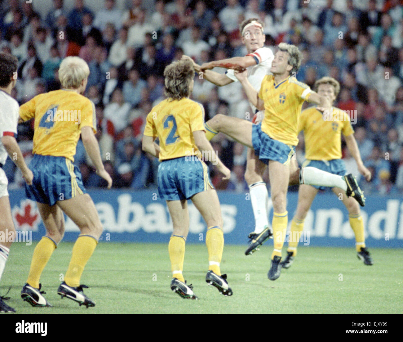 6 septembre 1989, la Suède v Angleterre. Terry Butcher vu ici en défense au cours de l'état civil Englands de qualification de la Coupe du Monde en Suède, Butcher a subi une profonde coupure à son front au début de la partie mais effectués après quelques points impromptus ont été insérés par le physiothérapeute et la tête couverte de bandages. Sa position constante de la balle - inévitable lors de la lecture dans le centre de la défense - désintégré les bandages et rouvert le coupé à la mesure que sa chemise blanche l'Angleterre était entièrement rouge par la fin de la partie. Banque D'Images