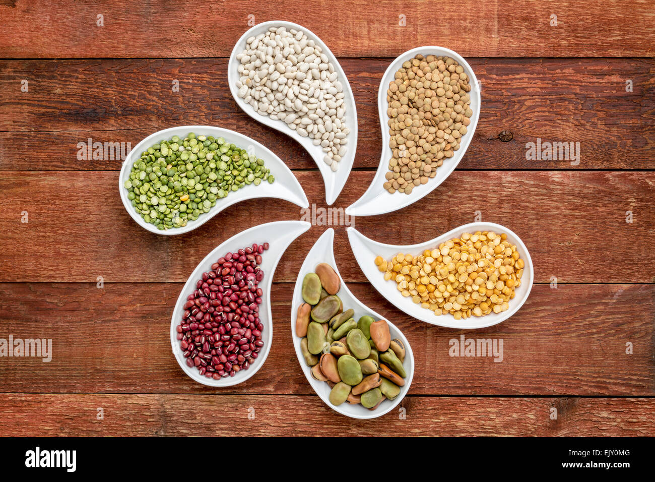 Variété de haricots, de lentilles et de pois en forme de larme contre bols, vue du dessus en bois rustique Banque D'Images