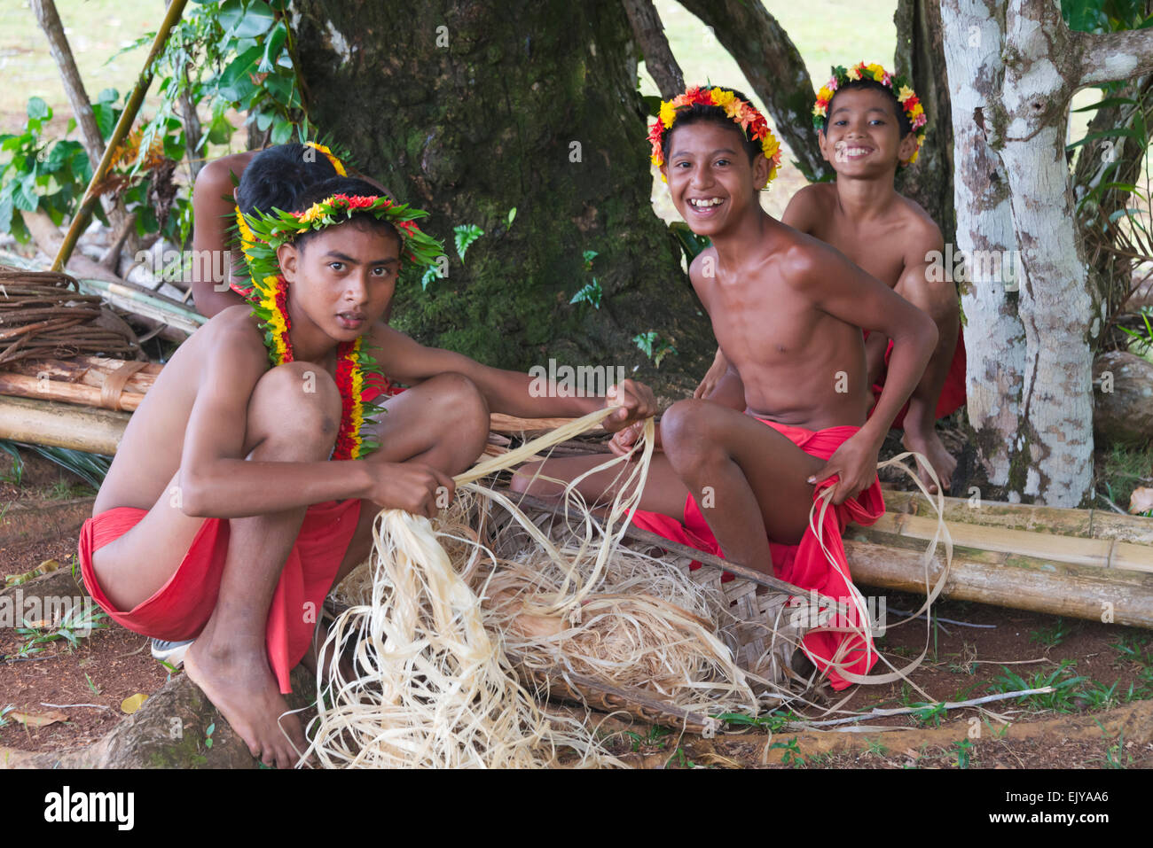 Les garçons à l'aide de palm l'écorce des arbres pour en faire de la corde, l'île de Yap (États fédérés de Micronésie Banque D'Images