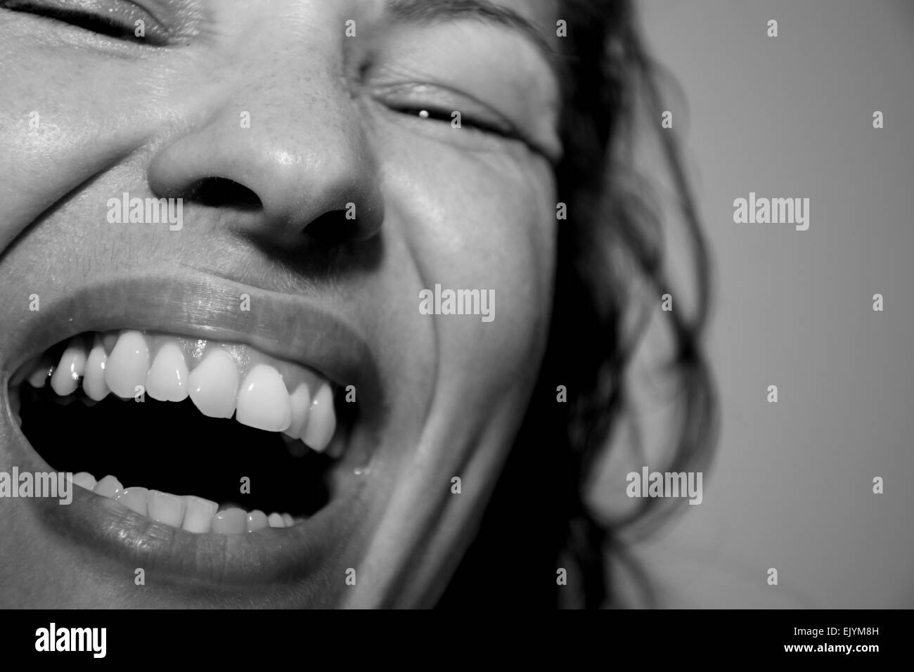 Closeup portrait of a pretty young woman Laughing Out Loud l'intérieur monochrome Banque D'Images