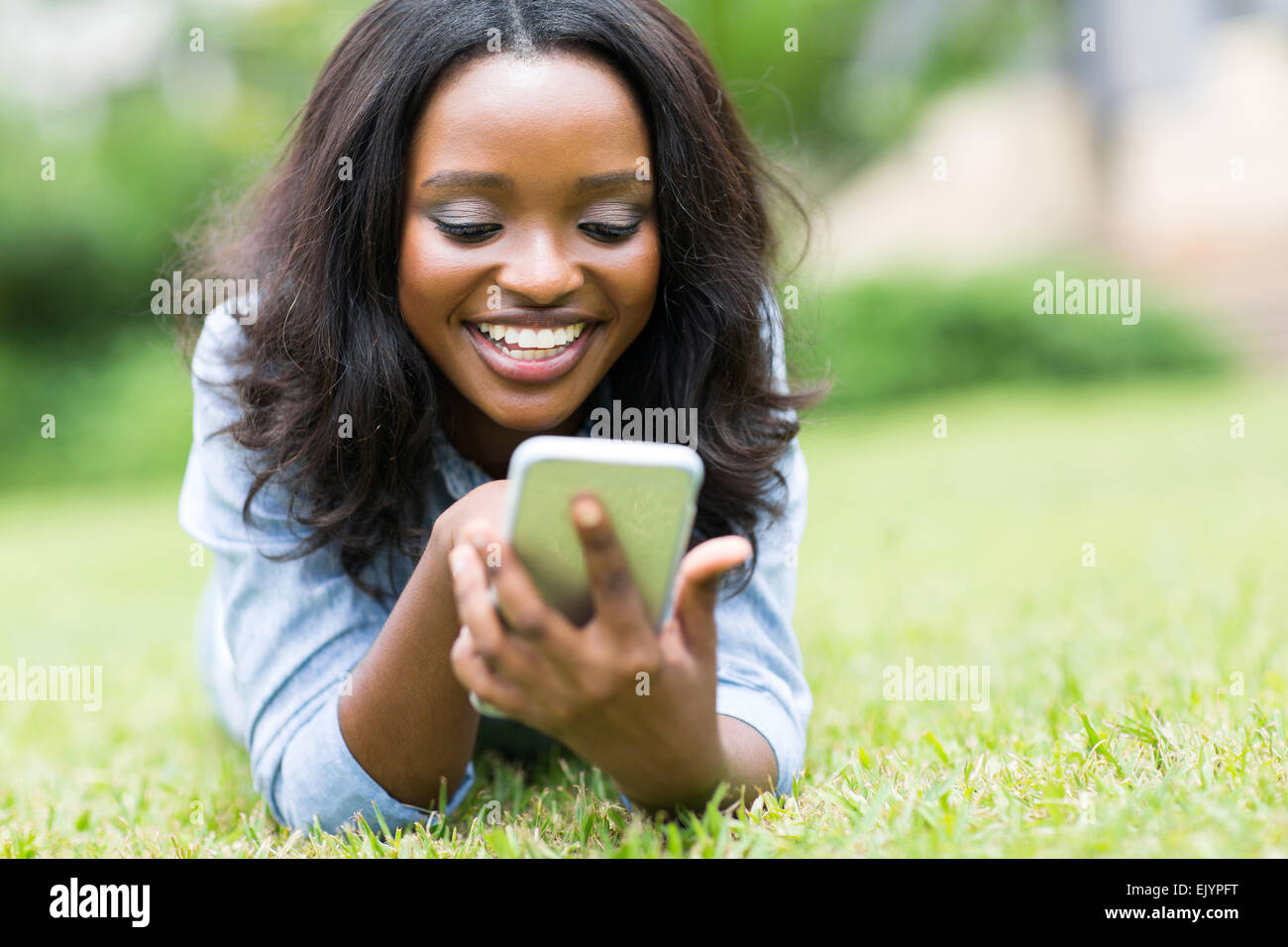 Cheerful African American Woman using smart phone Banque D'Images
