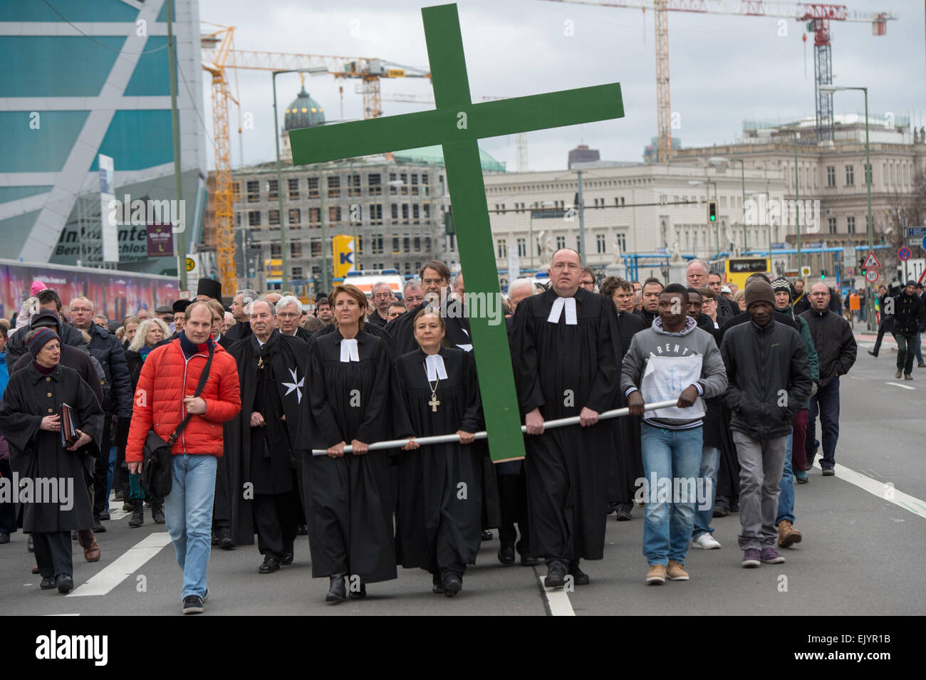 Berlin, Allemagne. 06Th avr, 2015. Prêtre Petra Zimmermann (L-R), le surintendant général, Ulrike Trautwein, surintendant Bertold Hoecker et réfugiés du Ghana David Porter une croix comme ils commencent la procession du Vendredi Saint à partir de la cathédrale de Berlin à Berlin, Allemagne, 03 avril 2015. La procession a conduit l'église de la Vierge Marie et la cathédrale St Hedwig parmi d'autres, avant qu'elle se termine à la cathédrale française sur la place de Gendarmenmarkt. À chaque participant de l'Arrête le prêtres lire des extraits du récit de la passion. Photo : Maurizio Gambarini/dpa/Alamy Live News Banque D'Images