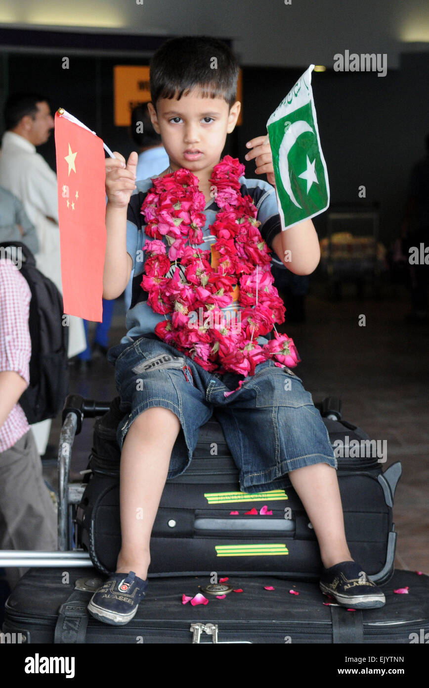 Rawalpindi (Pakistan). 3ème apr 2015. Un garçon Pakistanais évacués du Yémen est titulaire et drapeaux nationaux chinois pakistanais à l'Aéroport International Benazir Bhutto à Rawalpindi, au Pakistan, le 3 avril, 2015. Un groupe de 176 ressortissants pakistanais, qui avaient été bloqués dans la guerre du Yémen et évacués par un navire chinois, arrive à Islamabad le vendredi, selon les autorités de l'aviation. Credit : Ahmad Kamal/Xinhua/Alamy Live News Banque D'Images