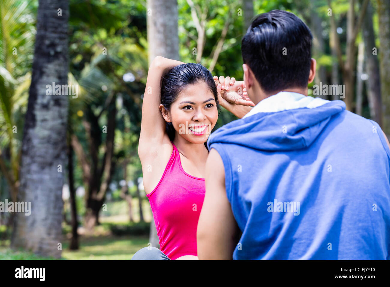 Femme Asiatique et l'homme, un couple, au cours de gymnastique stretching pour le sport fitness à tropical park Banque D'Images