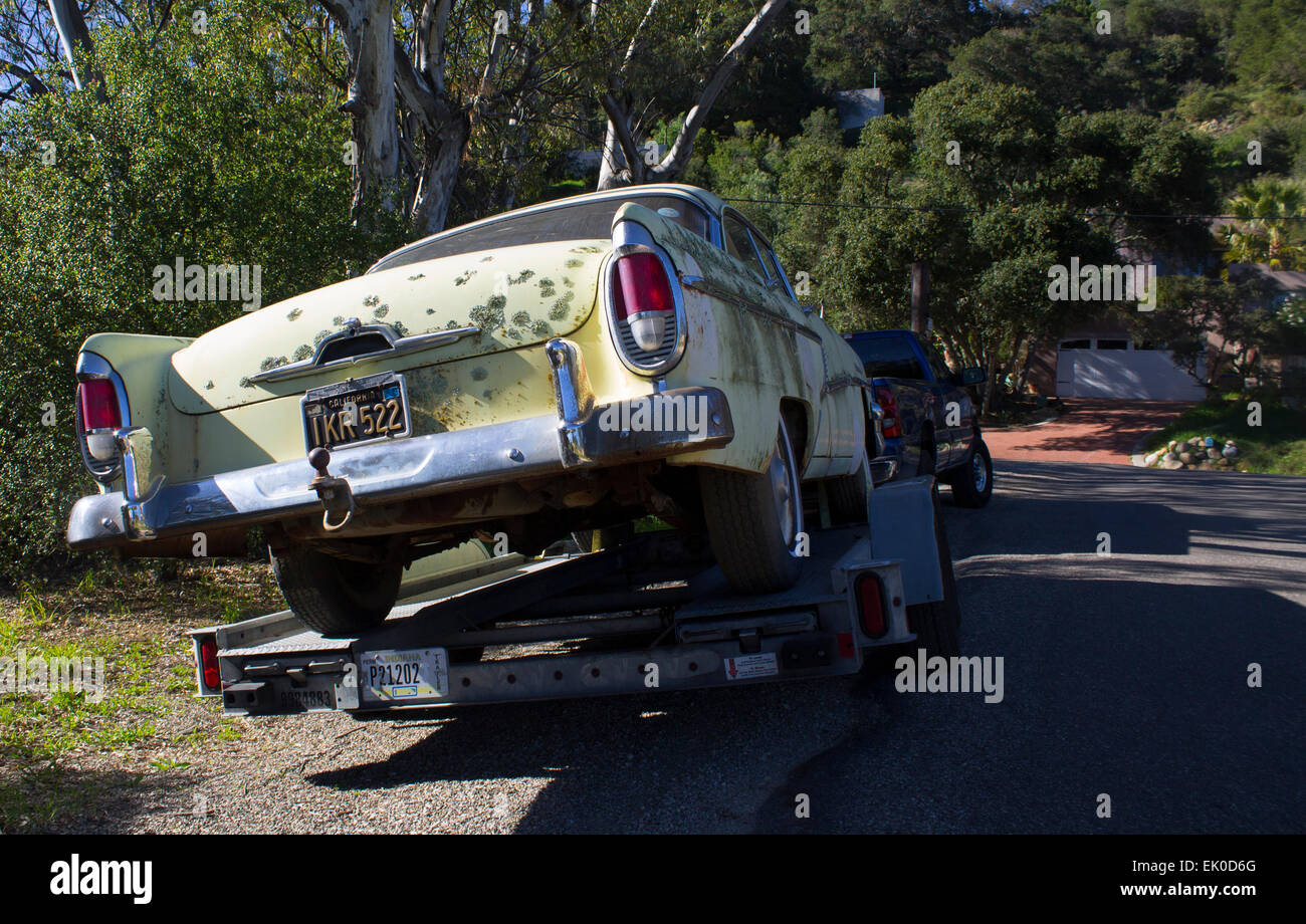 Vieille voiture jaune avec le lichen sur il remorqué Banque D'Images Vieille voiture jaune avec le lichen sur il remorqué Banque D'Images