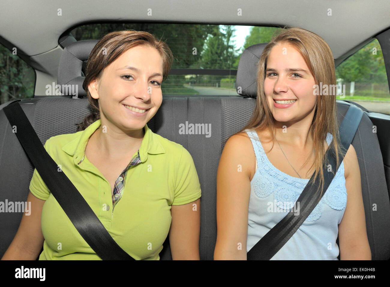 Deux jeunes femmes assis dans le siège arrière d'une voiture, ceinture bouclée Banque D'Images