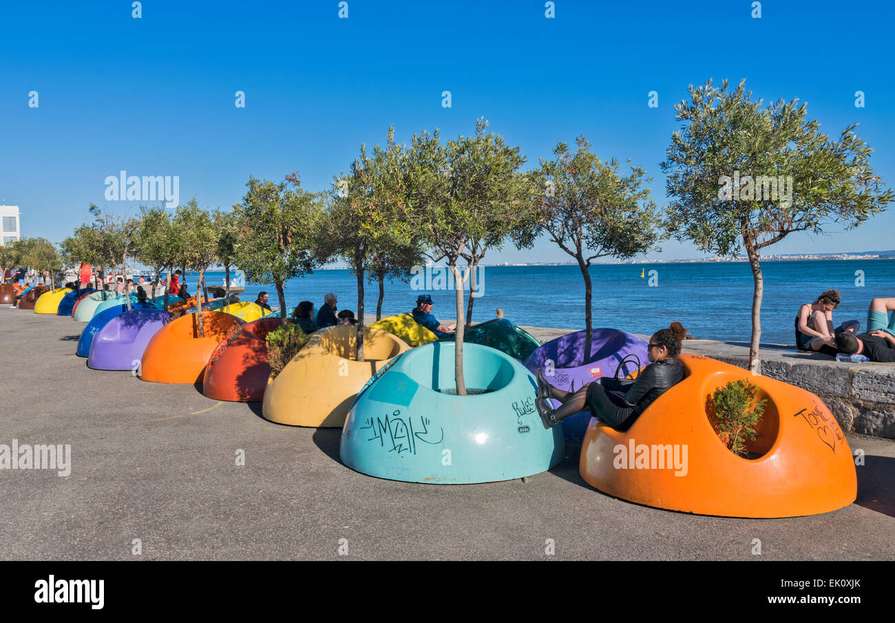 PORTUGAL LISBONNE LE FRONT DE LA RIVIÈRE TAGUS et chaises de couleur à l'AVENIDA DA RIBEIRA DAS NAUS Banque D'Images