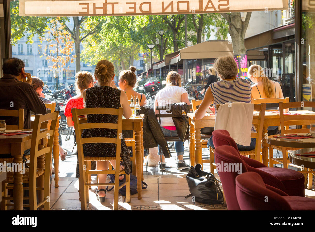 Profiter de la lumière du soleil d'automne parisiens dans un café dans le Marais, Paris, France Banque D'Images