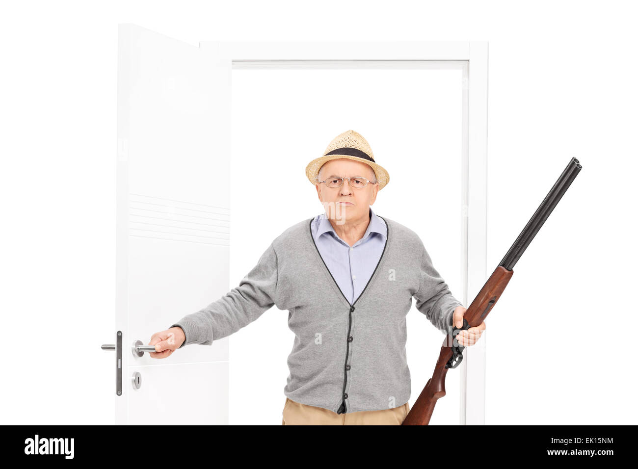 Angry man hat tenant un fusil de chasse et la marche à pied par une porte ouverte isolé sur fond blanc Banque D'Images