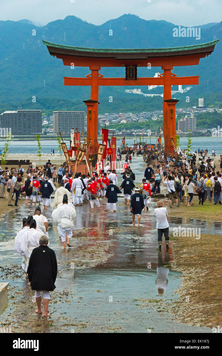 Prêtres à Torii du sanctuaire d'Itsukushima au cours de Kangen-sai Festival, Miyajima, Japon Banque D'Images