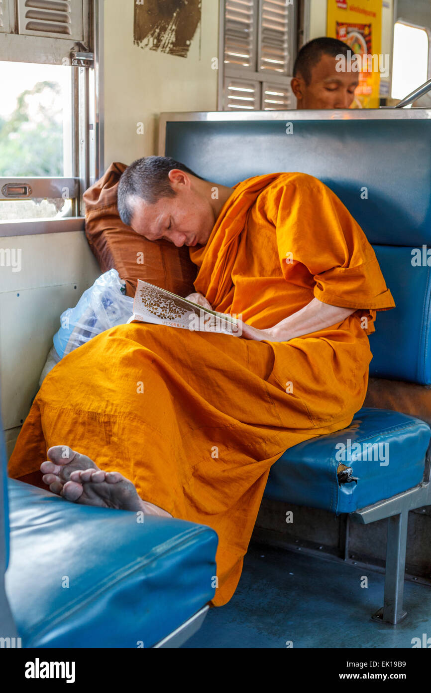 Un jeune moine dormir sur un train, Thaïlande Banque D'Images