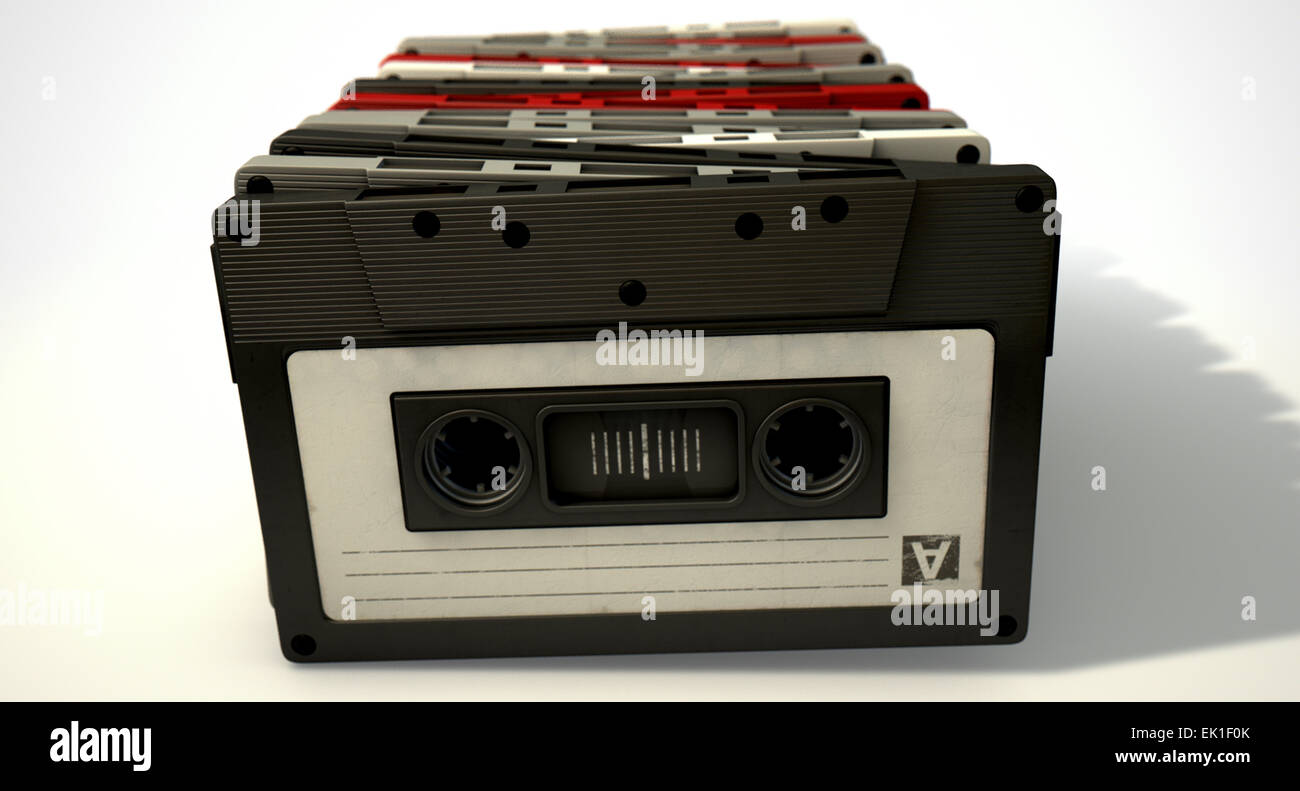 Une vue en gros plan d'une collection de vintage cassette audio alignés dans une rangée sur un cas isolé sur fond blanc Banque D'Images