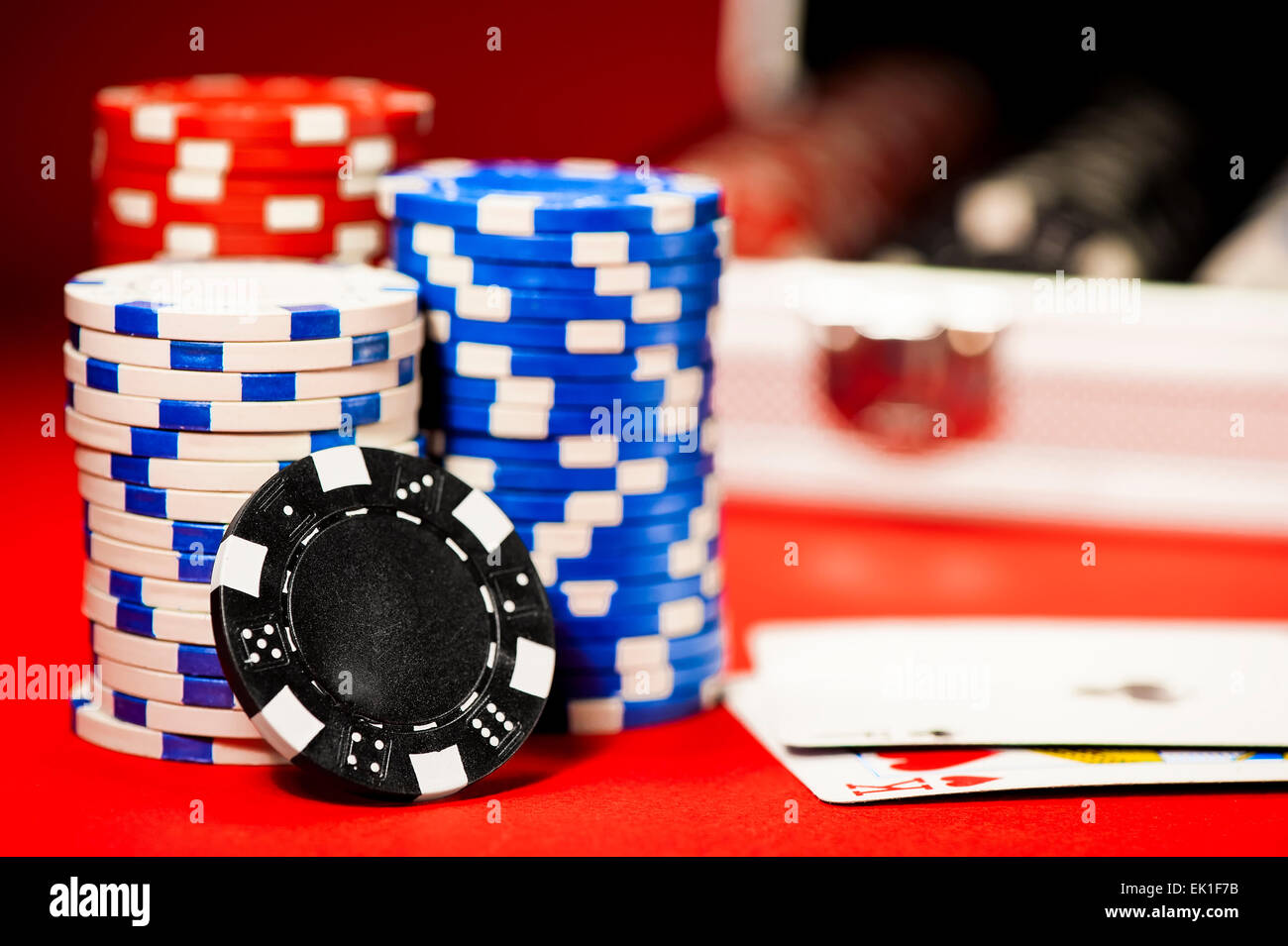 Pile de jetons colorés sur une table rouge Banque D'Images