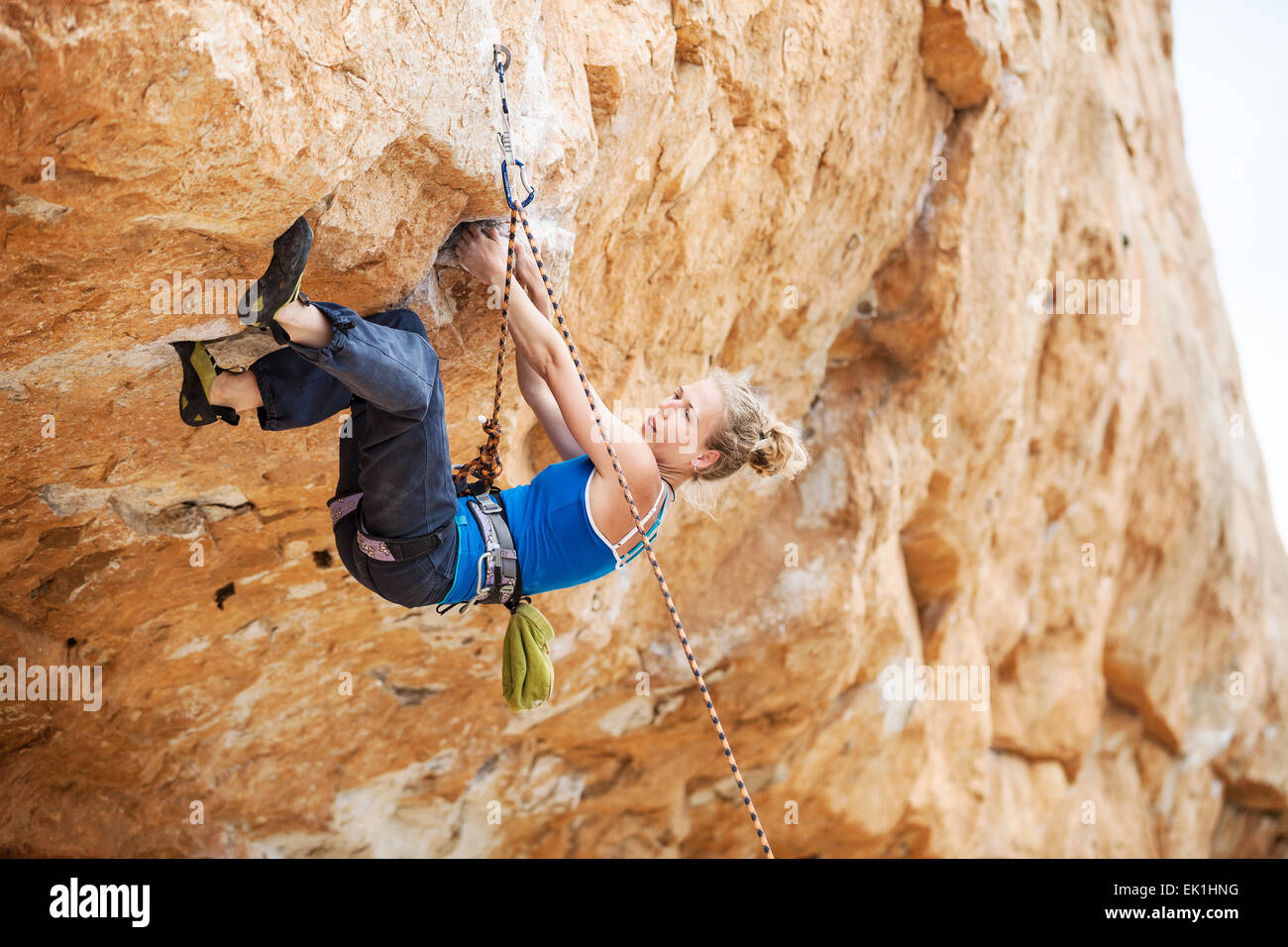 Young female rock climber luttant pour rendre la circulation vers le haut Banque D'Images