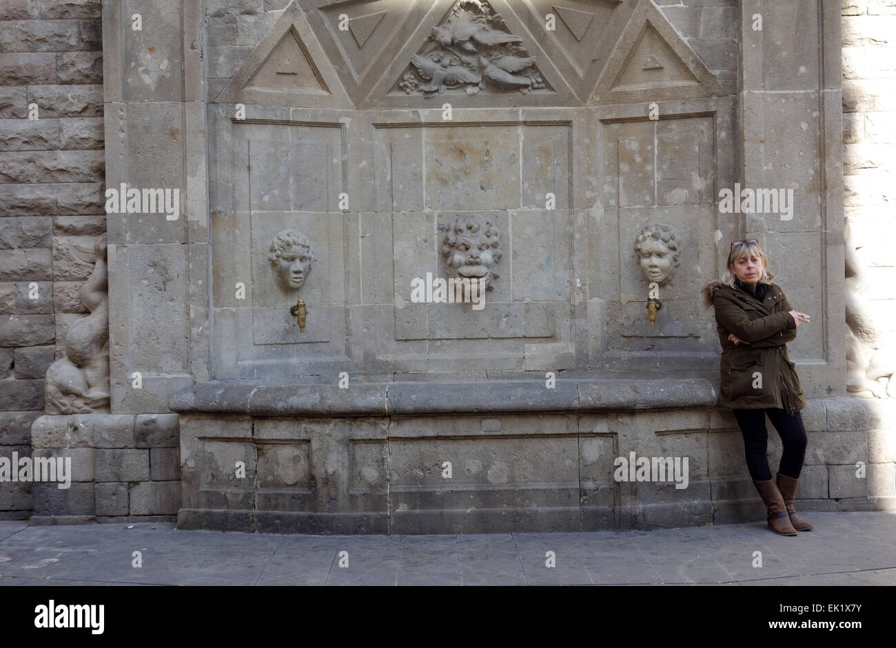 Femme fumant et Comité permanent par fontaine traditionnelle dans El Raval, Barcelone, Catalogne, Espagne Banque D'Images