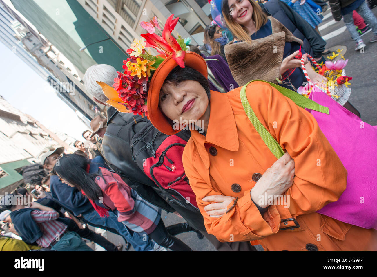 Femme dans un comté d'orange et rose sac d'épaule portant un bonnet de Pâques promenades dans l'Easter Parade sur la Cinquième Avenue de Manhattan. Banque D'Images