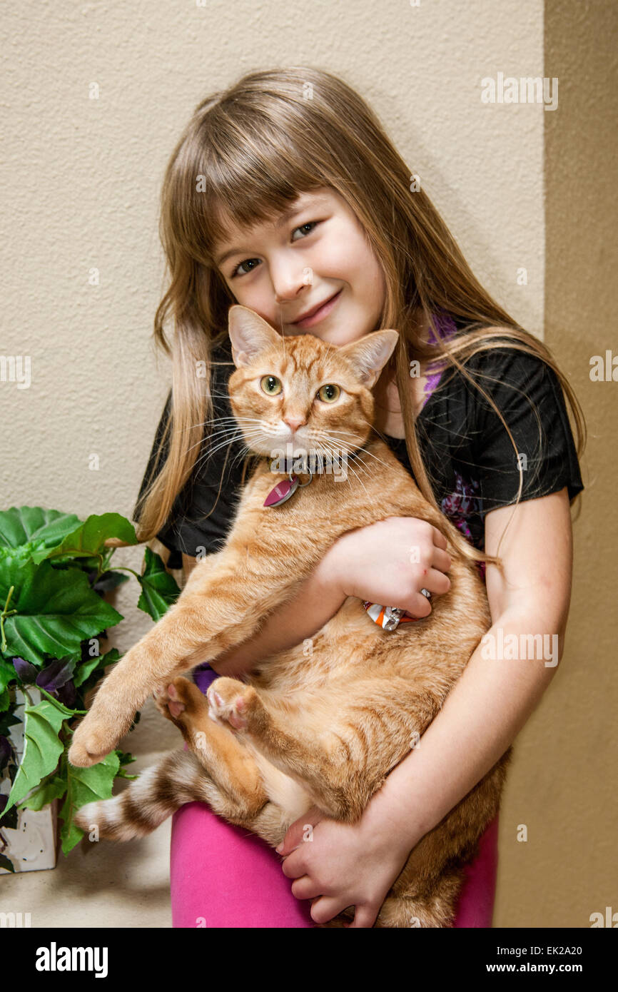 Sept ans, fille de câlins avec son chat Banque D'Images